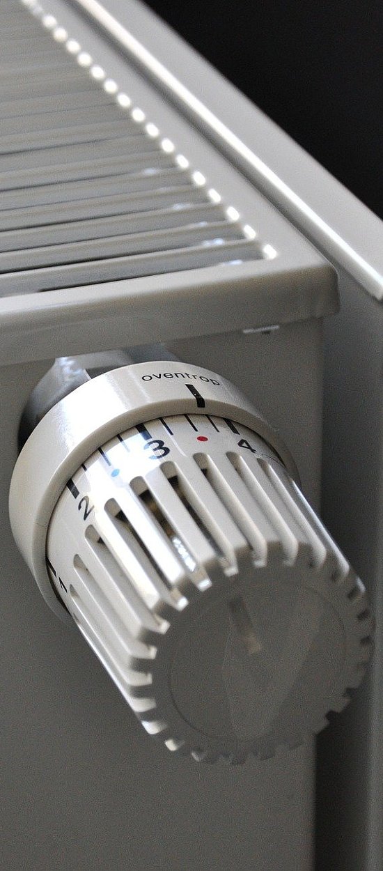Thermostaatkraan gemonteerd op een witte radiator met rooster