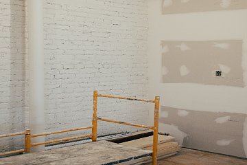 Wit geschilderde muur met gyproc wand en stelling